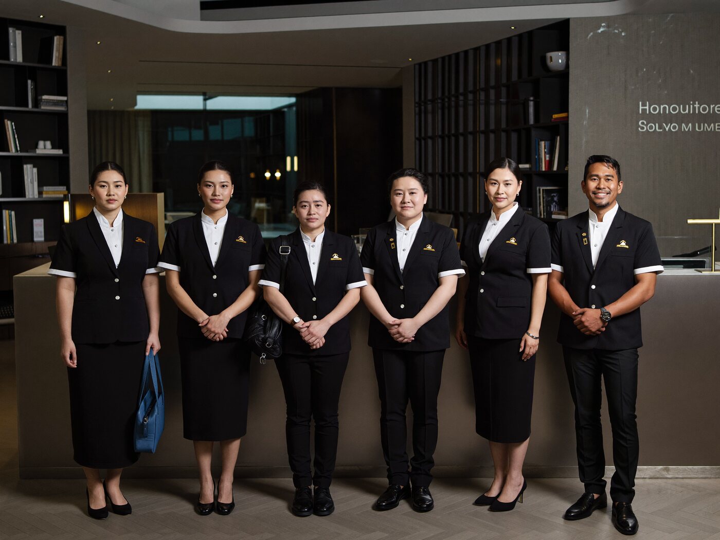 Hospitality and facility staff lined up in a hotel lobby